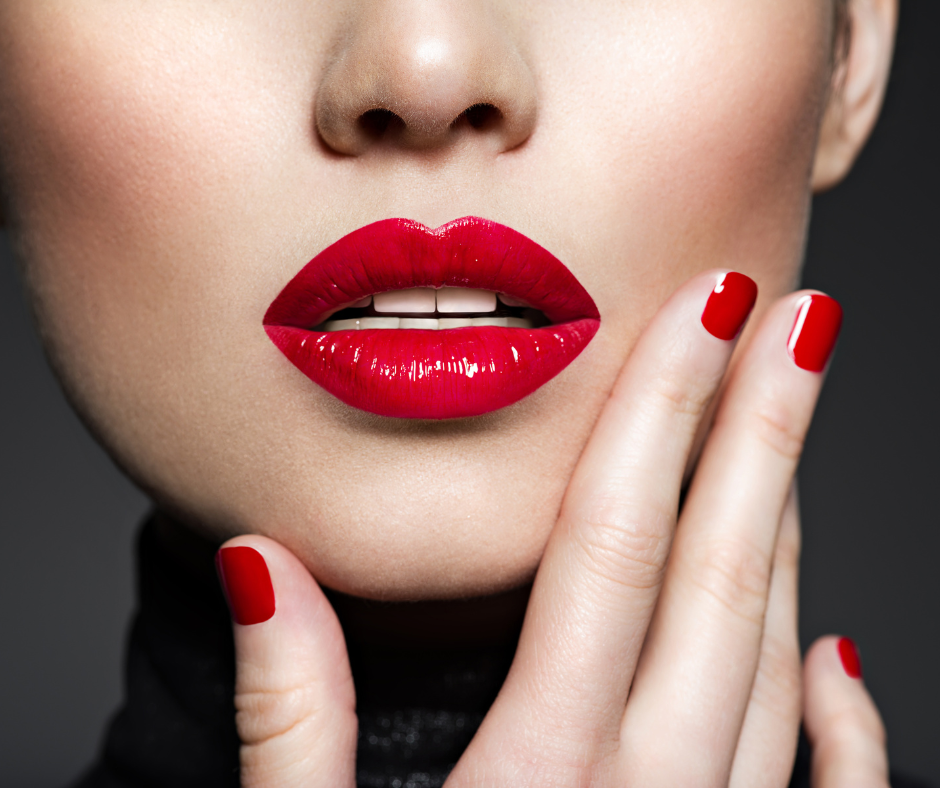 Tvář ženy s červenou rtěnkou. Dotýká se tváře svou dlaní.